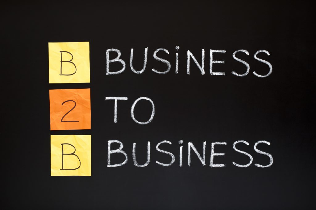 B2B acronym - BUSINESS TO BUSINESS. Concept made with sticky notes and white chalk on a blackboard.
